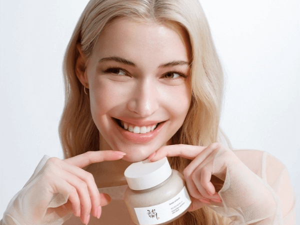 Smiling woman holding the Beauty of Joseon Wash Off Mask, a Korean skincare treatment for deep cleansing and skin nourishment.